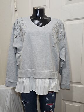 Calligraphie Light Gray V-Neck Embroidered Sweatshirt with White Ruffle Hem.